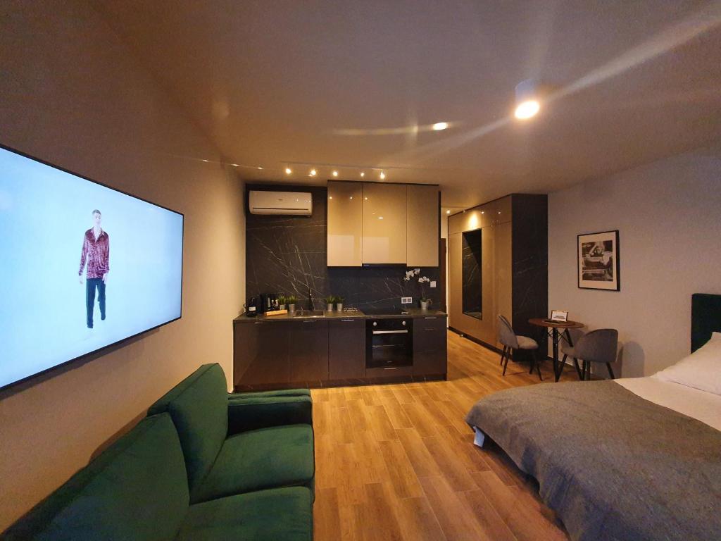 ein Wohnzimmer mit Bett und Flachbildfernseher in der Unterkunft APARTAMENT W CHMURACH- 15 PIĘTRO OSIEDLE TYSIĄCLECIA- parking w hali garażowej, wielki taras z widokiem na zachód słońca in Kattowitz