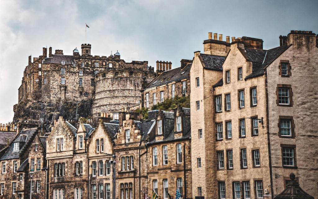 an old building with a castle in the background at Greyfriars Studio Edinburgh in Edinburgh