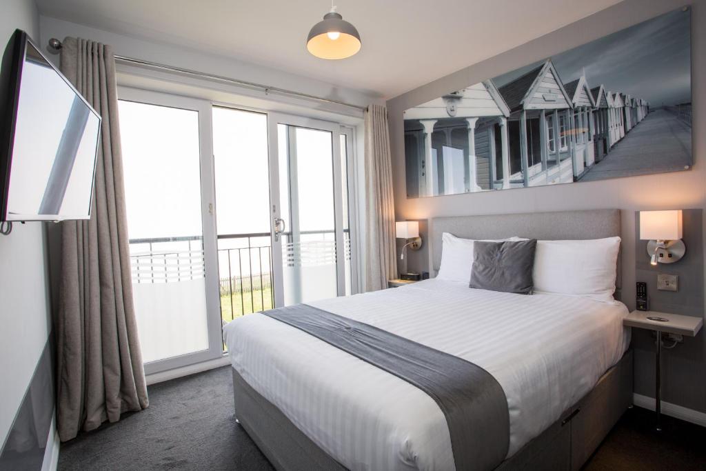 a bedroom with a large bed and a large window at Allseasons Hotel in Lowestoft