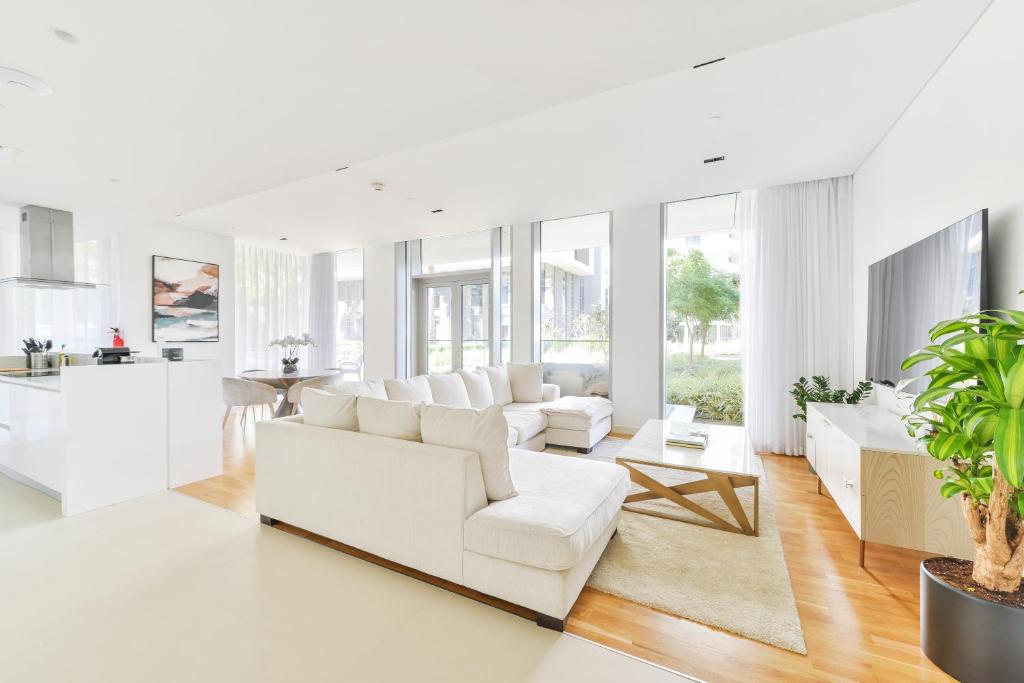uma sala de estar com mobiliário branco e uma cozinha em Elegant 2+1 BR with Fantastic Views of Ain Dubai em Dubai
