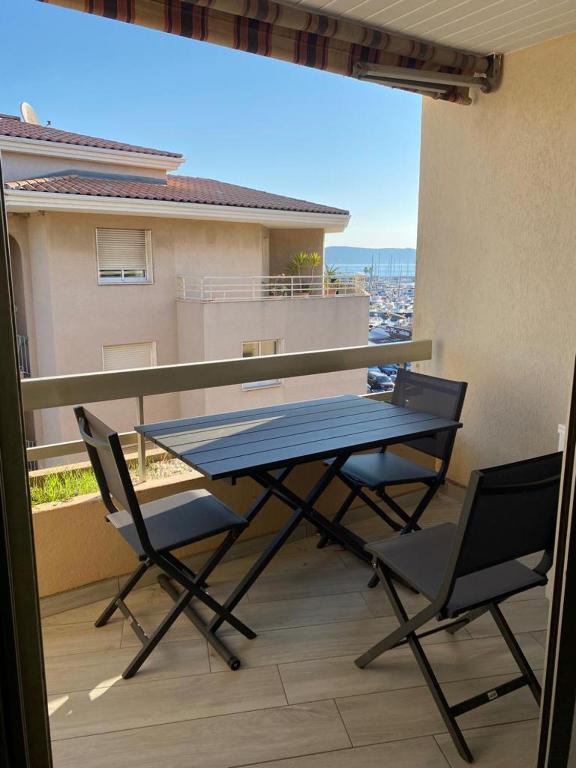 une table et des chaises sur un balcon avec vue dans l'établissement LE DIATOMEE - RUE DU PORT, à Cavalaire-sur-Mer