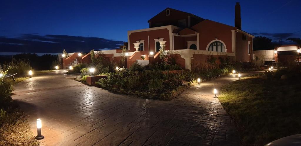 una casa con luces en una entrada de noche en Palazzino Di Nionio, en Karavádhos