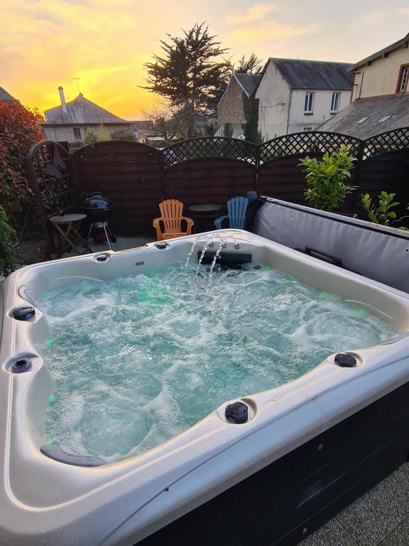 a jacuzzi tub with water in a backyard at Mont Naïa in Pontorson