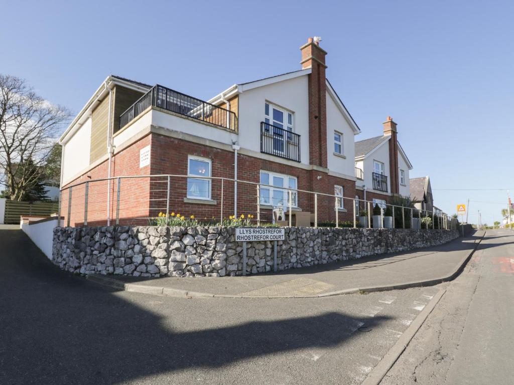 un grande edificio in mattoni con un muro di pietra di Benllech Coastal Retreat a Benllech