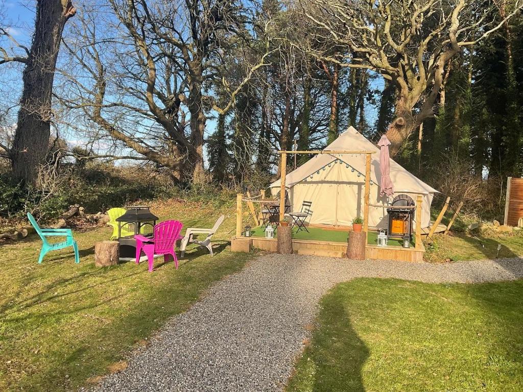 um jardim com cadeiras e uma casa de brincar em Garden County Glamping em Newtownmountkennedy