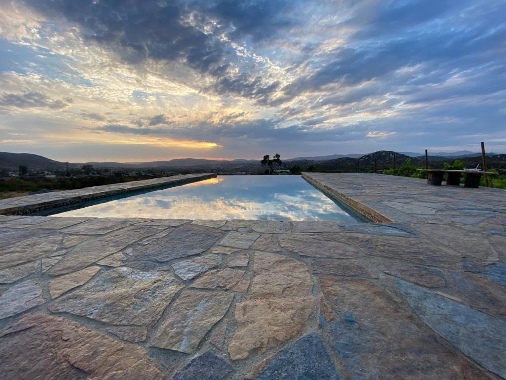 un reflejo del cielo en un charco de agua en Suites Nativo - Beautiful Vineyard & Valley View, en Valle de Guadalupe