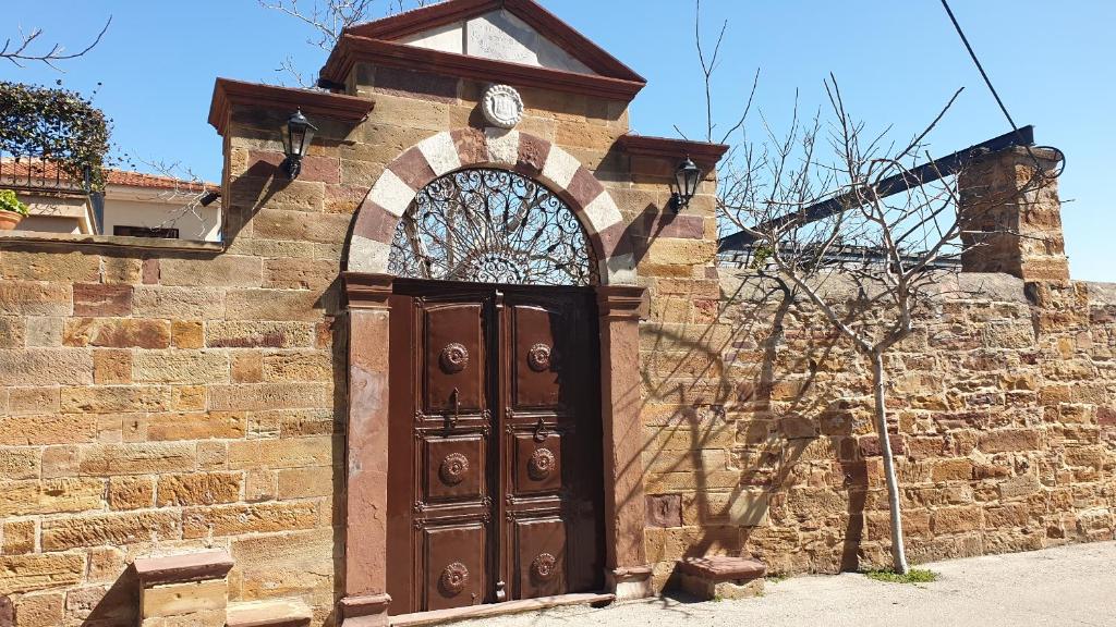 a wooden door with a clock on top of a brick building at Arhodico Simou mansion in Kambos