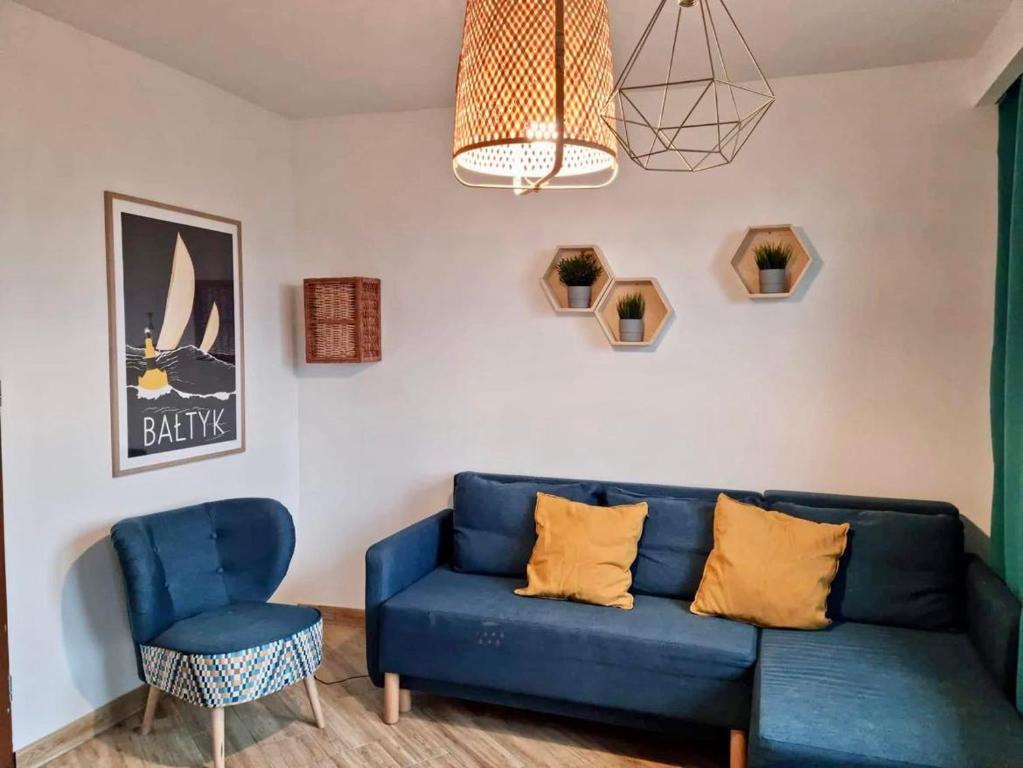 salon z niebieską kanapą i krzesłem w obiekcie Sea View Apartament 5 min od morza w Gdańsku