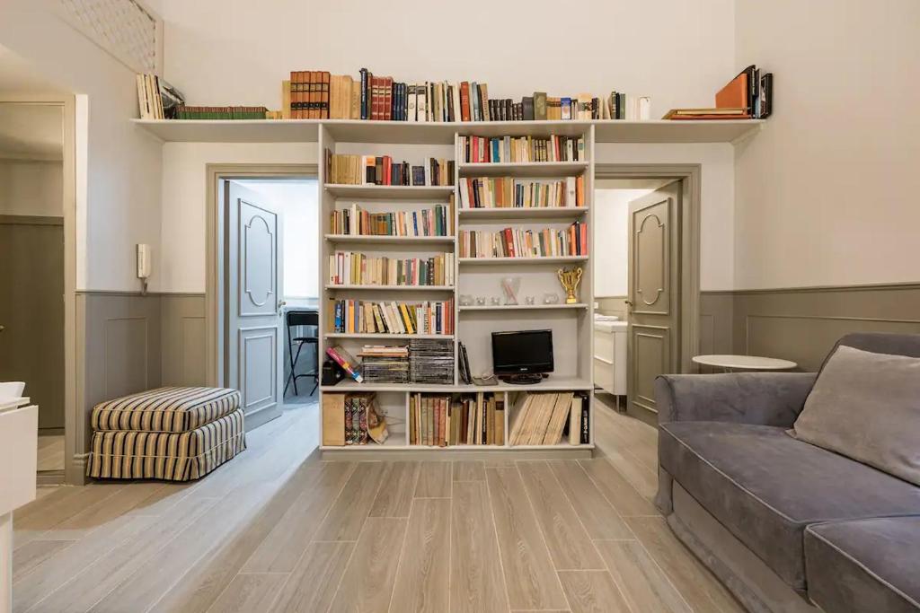 ein Wohnzimmer mit einem Sofa und Bücherregalen in der Unterkunft Bianca - Frezza Little Suite at Piazza di Spagna in Rom