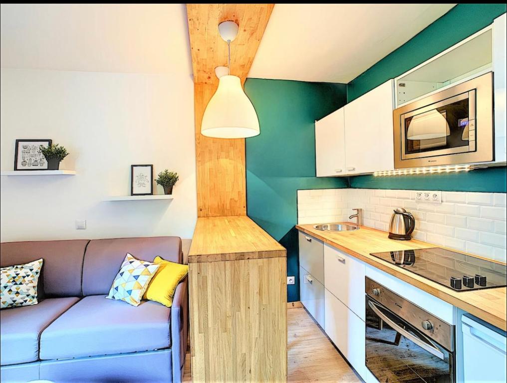 a living room with a couch and a kitchen at Centre Saint-Gervais Studio Vert moderne 2 pers proche télécabine in Saint-Gervais-les-Bains