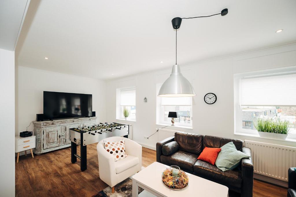 a living room with a couch and a tv at Ferienwohnung am Lindbruch in Niederkrüchten