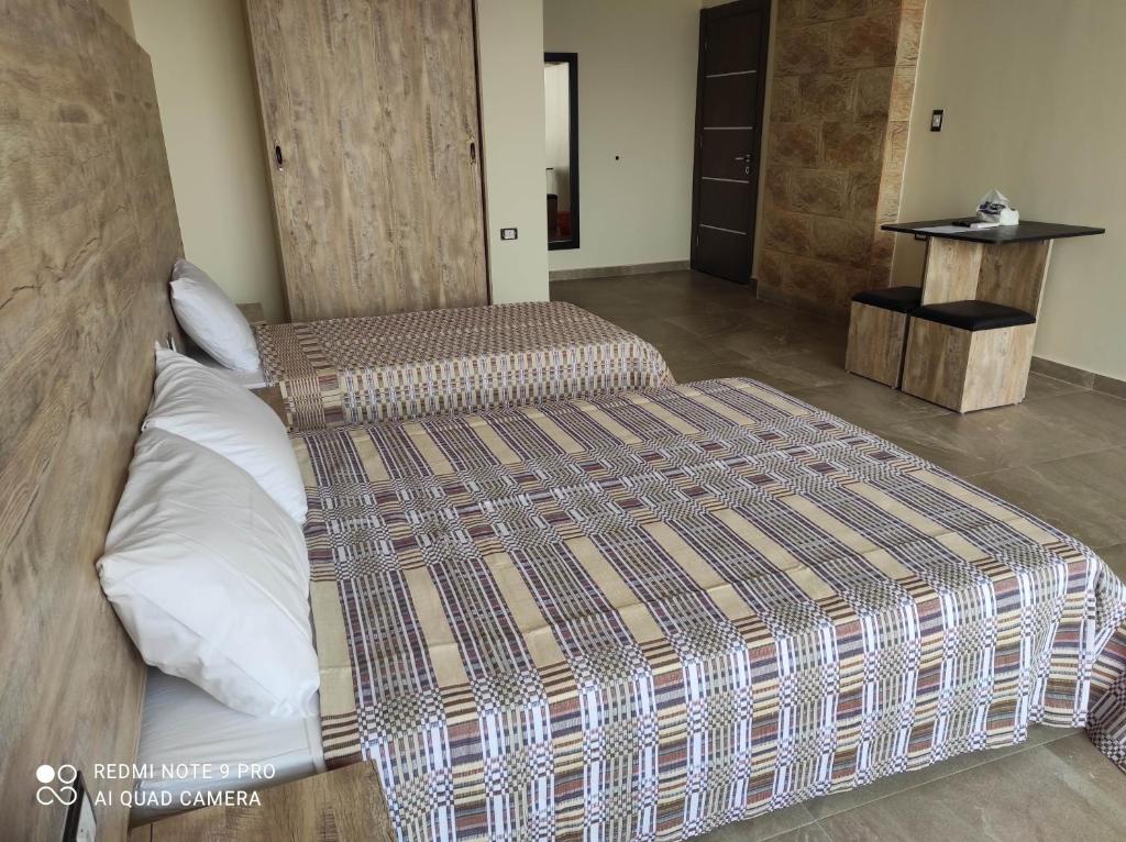 a bedroom with two beds in a room at pyramids view suite/vista piramidi in Cairo