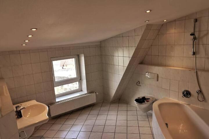 ヴィルヘルムスハーフェンにある1 ZKB DG Ferienwohnung - Direkt am Kurpark - Zentrale Lageの洗面台、浴槽、トイレを備えたバスルーム