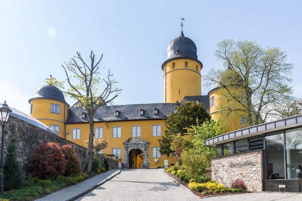 ein großes gelbes Gebäude mit zwei Türmen in der Unterkunft Hotel Schloss Montabaur in Montabaur