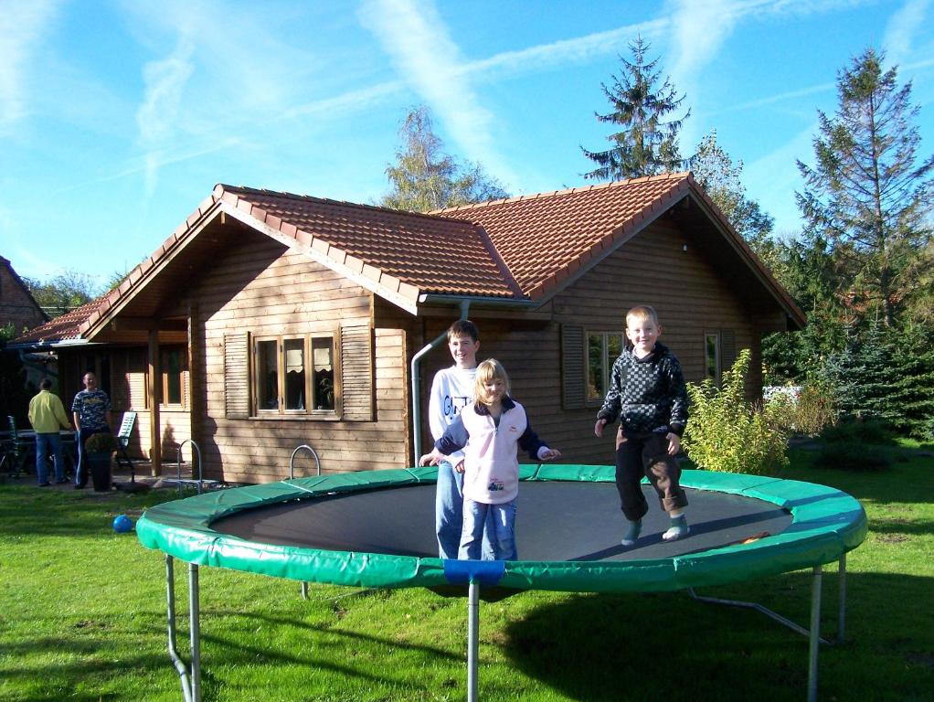 a man and two children playing on a trampoline at Blockhaus in Kägsdorf