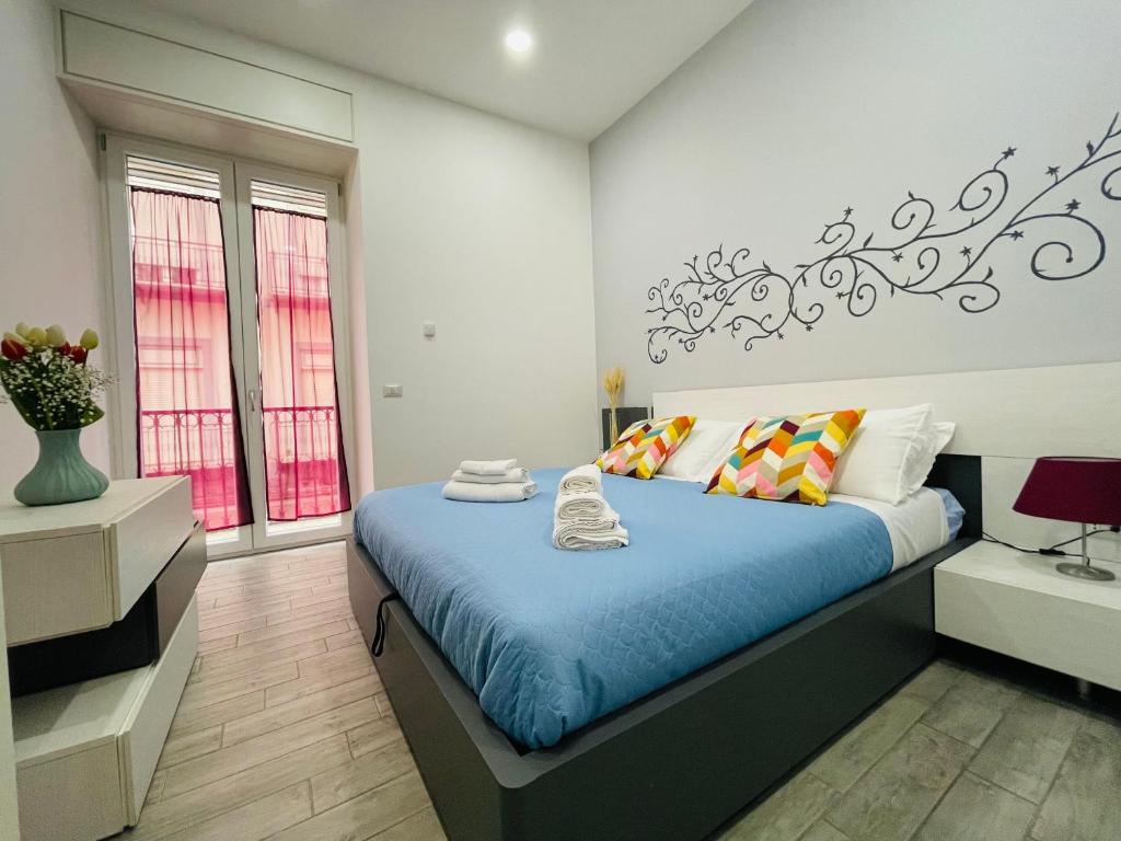 1 dormitorio con cama con sábanas azules y ventana en Casa Duomo, en Nápoles