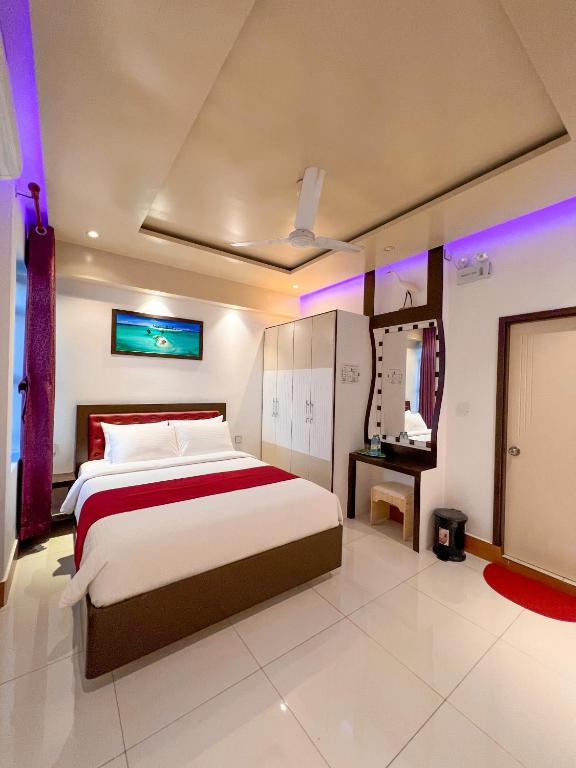 una camera da letto con un grande letto con luci viola di Sunview Residence a Kaashidhoo