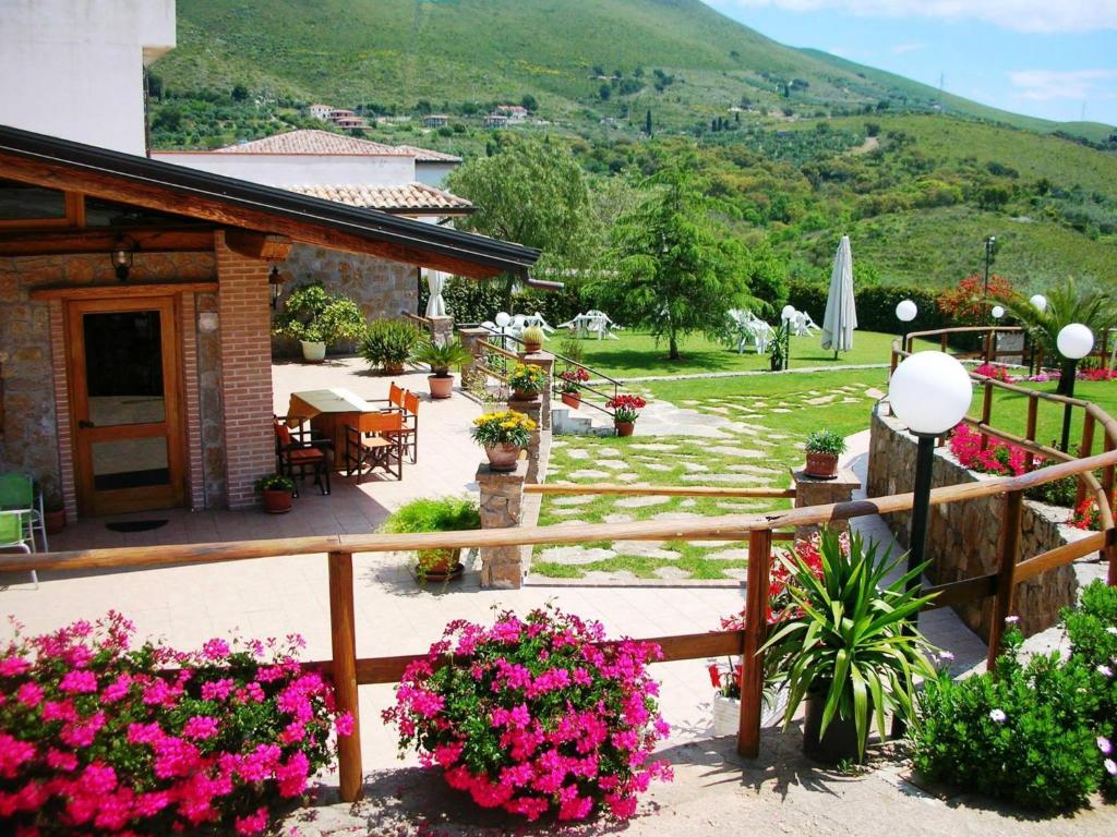 uma varanda com flores cor-de-rosa e uma casa em Albergo Villa Riccio em Itri