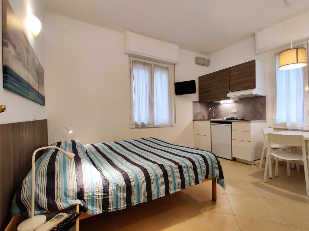 Il comprend une petite chambre avec un lit et une cuisine. dans l'établissement Residence Glicini, à Finale Ligure