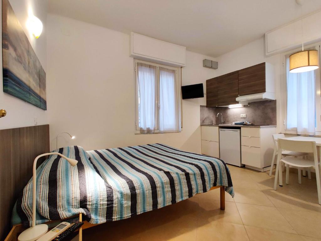 a small bedroom with a bed and a kitchen at Residence Glicini in Finale Ligure