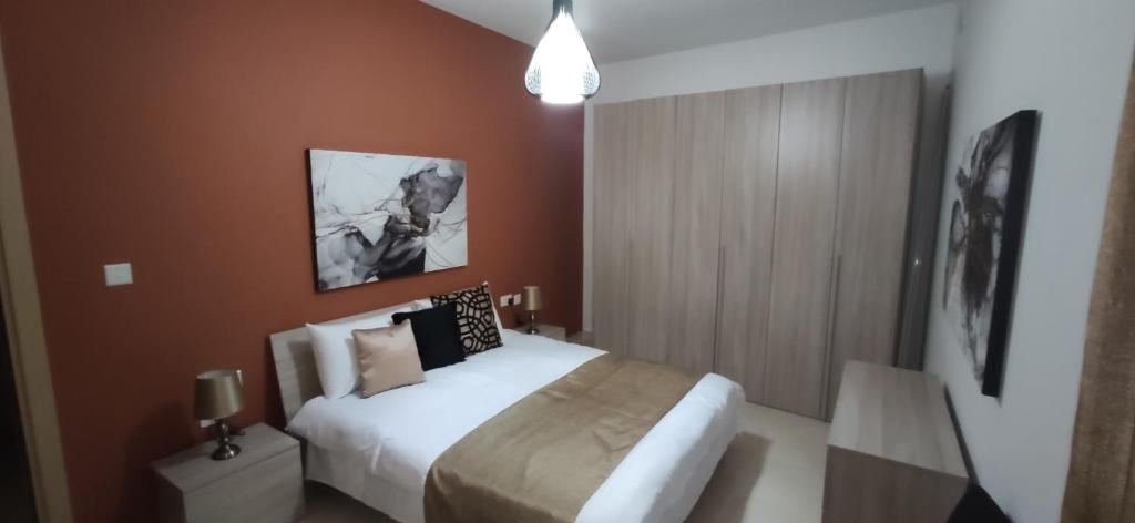 una camera con un letto bianco e una parete marrone di Searenity a Marsaxlokk