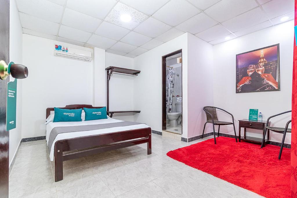 1 dormitorio con cama y alfombra roja en Ayenda Vanguard, en Yopal