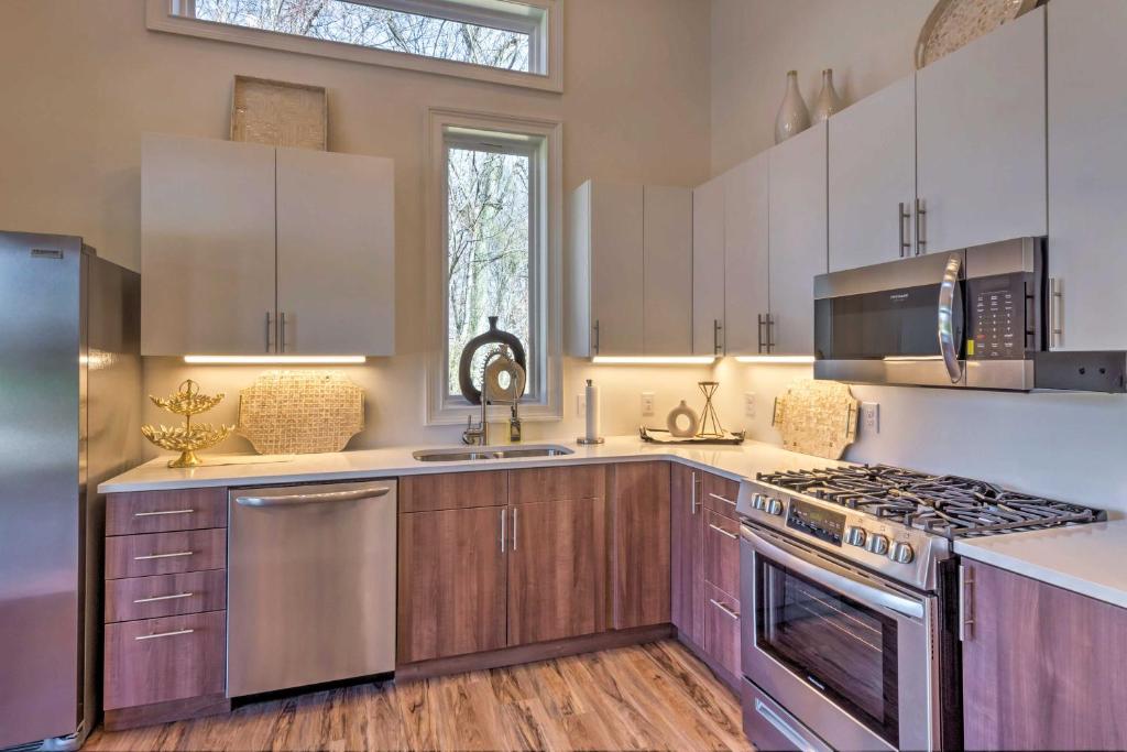 una cocina con armarios de madera y electrodomésticos de acero inoxidable en Upscale and Quiet Paducah Retreat on 15 Acres! en Paducah