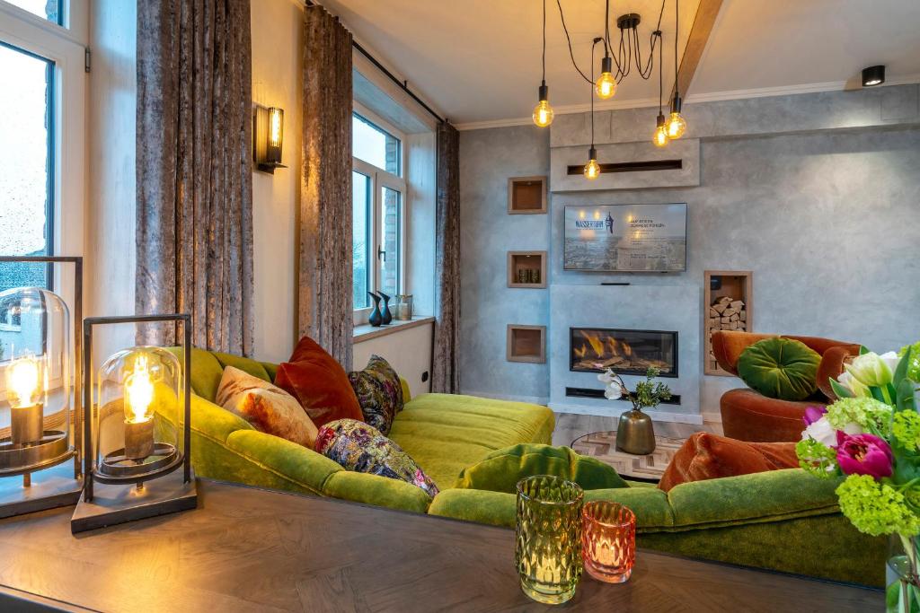 a living room with a green couch and a fireplace at Apartment Deluxe - a64667 in Bad Segeberg