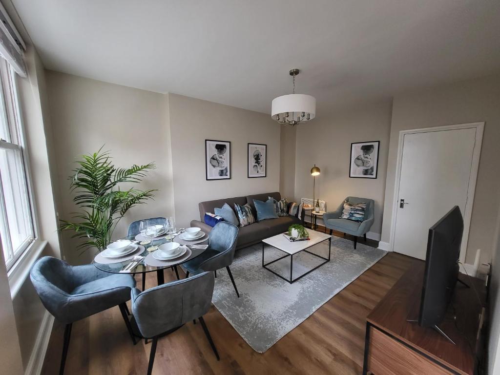 a living room with a couch and a table and chairs at 1 Bed Apartment Russell Square in London