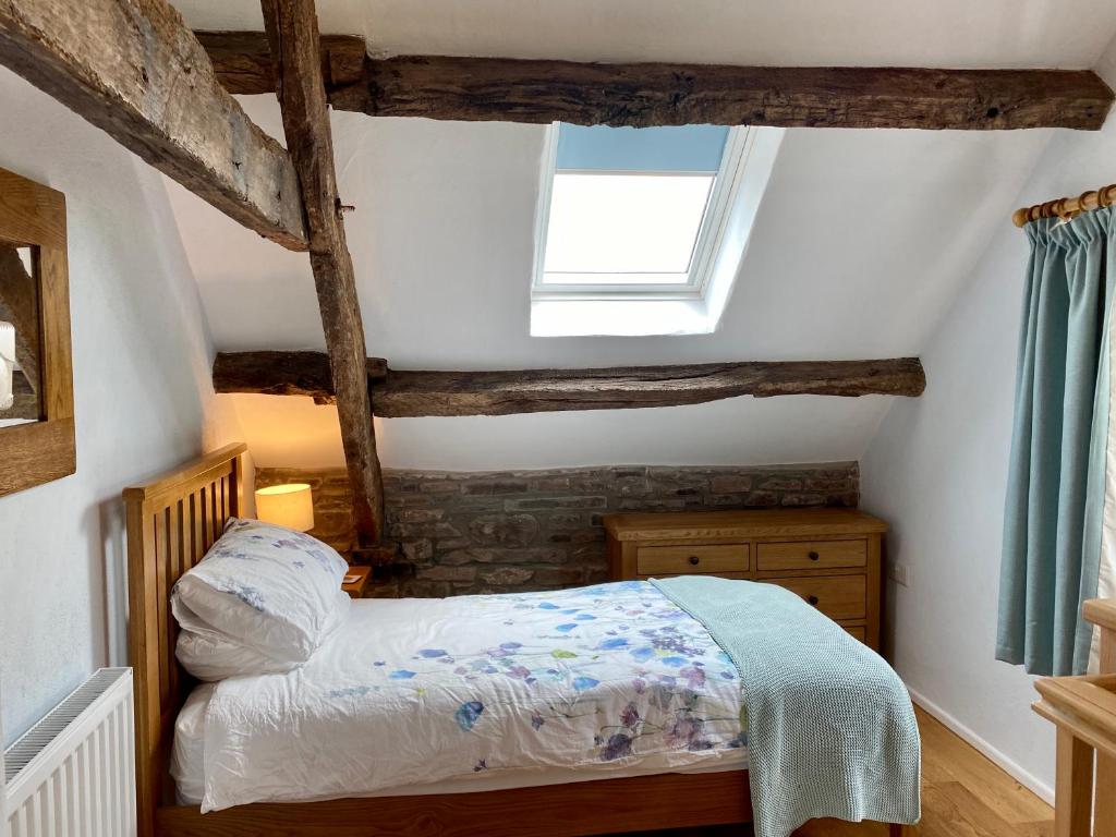 a small bedroom with a bed and a window at Pant Llwyd Farm in Llangynidr