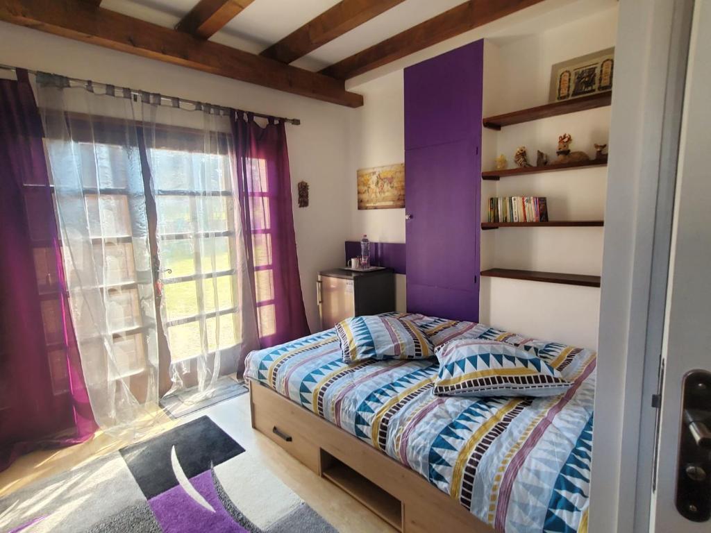 a bedroom with purple walls and a bed and a window at Maison Le Lézard chez Amalia et Fred in Thonon-les-Bains