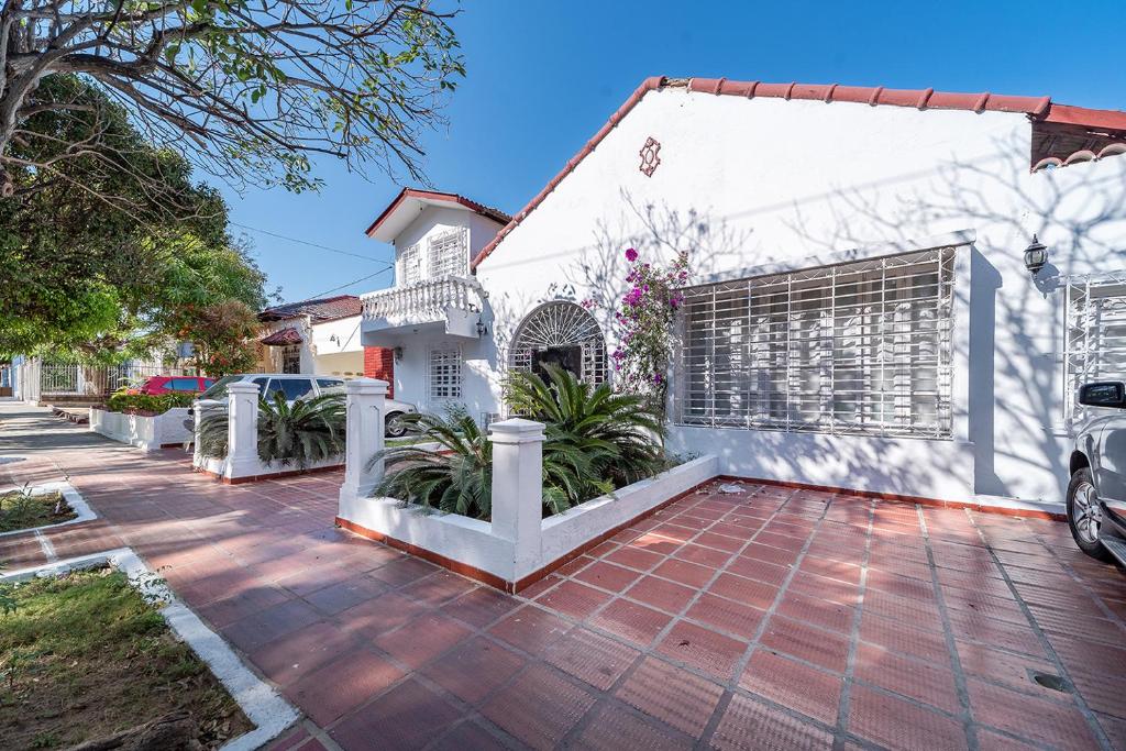 een wit huis met een poort en een oprit bij Hotel Mar di Plata in Barranquilla