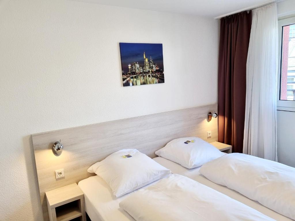Postel nebo postele na pokoji v ubytování Adler Hotel Frankfurt
