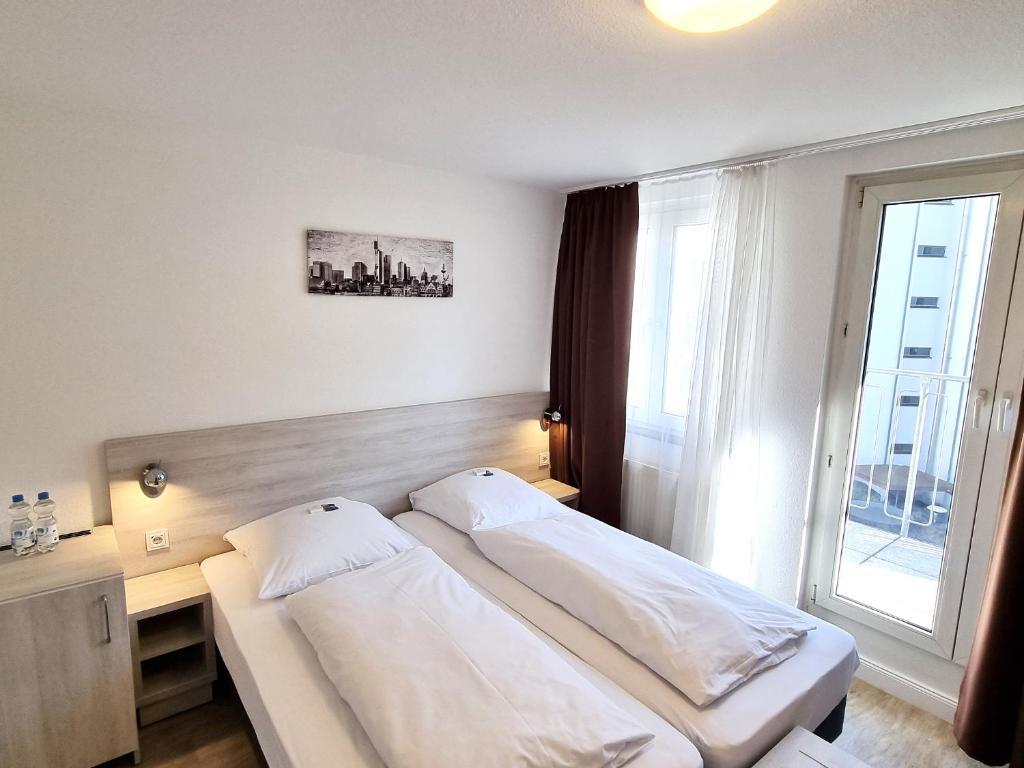 Postel nebo postele na pokoji v ubytování Adler Hotel Frankfurt