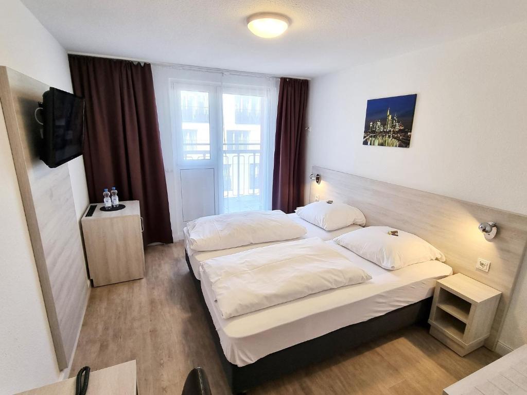 Postel nebo postele na pokoji v ubytování Adler Hotel Frankfurt
