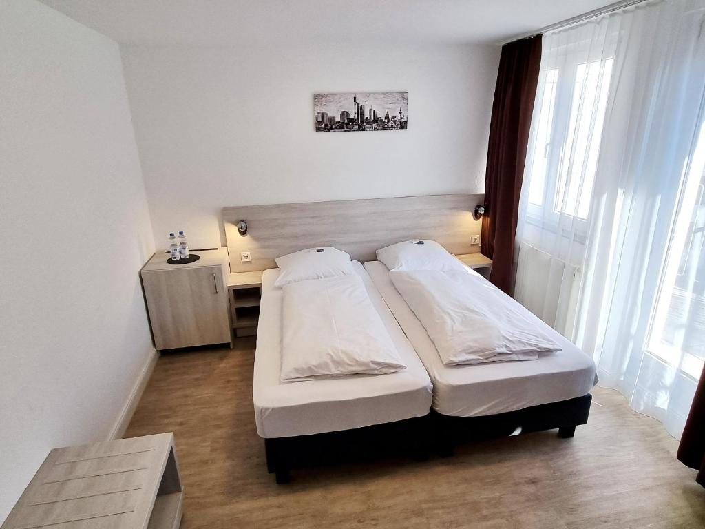 Postel nebo postele na pokoji v ubytování Adler Hotel Frankfurt