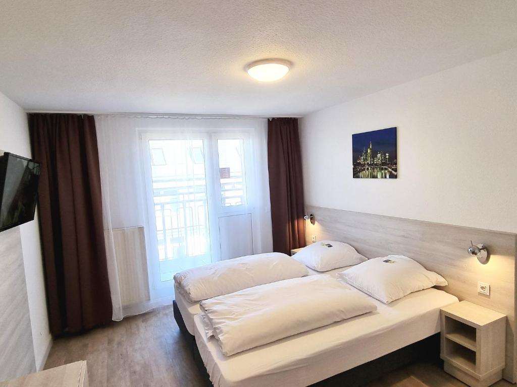 Postel nebo postele na pokoji v ubytování Adler Hotel Frankfurt