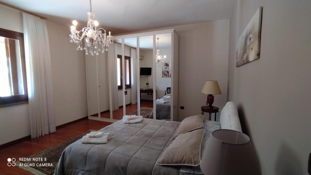Un dormitorio con una cama grande y una lámpara de araña. en Golfo Asinara Suite guest house con vasca idromassaggio R4976, en Sorso