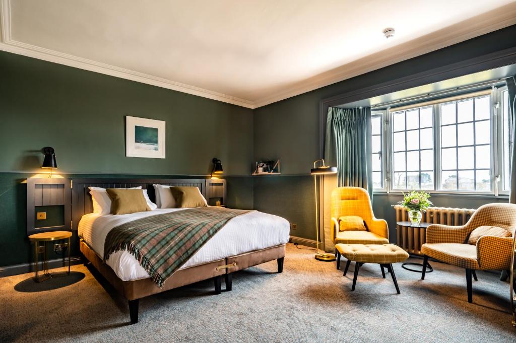 a bedroom with green walls and a bed and a chair at Royal Marine Hotel in Brora