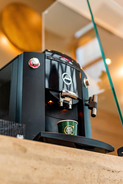 a coffee maker with a cup on top of a counter at Jade Hotel Brasília in Brasilia