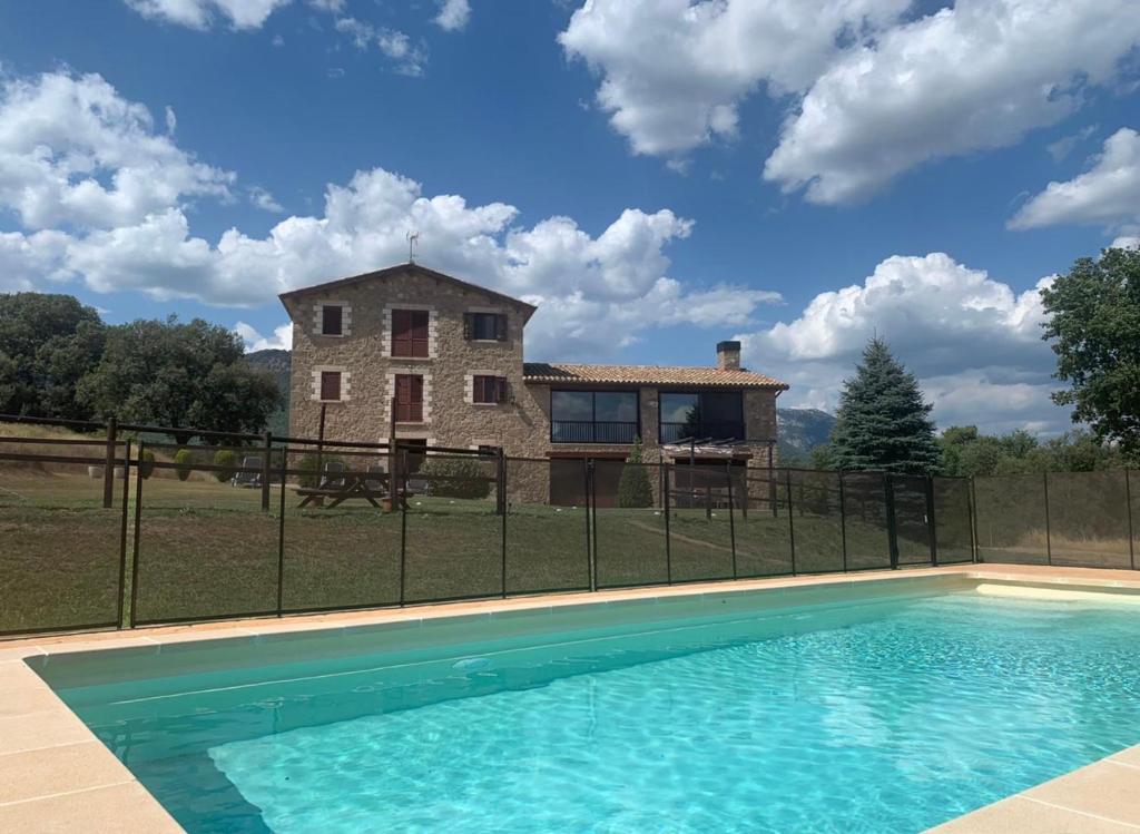 una casa y una piscina frente a una casa en Casa Cal Saboya en L'Espunyola