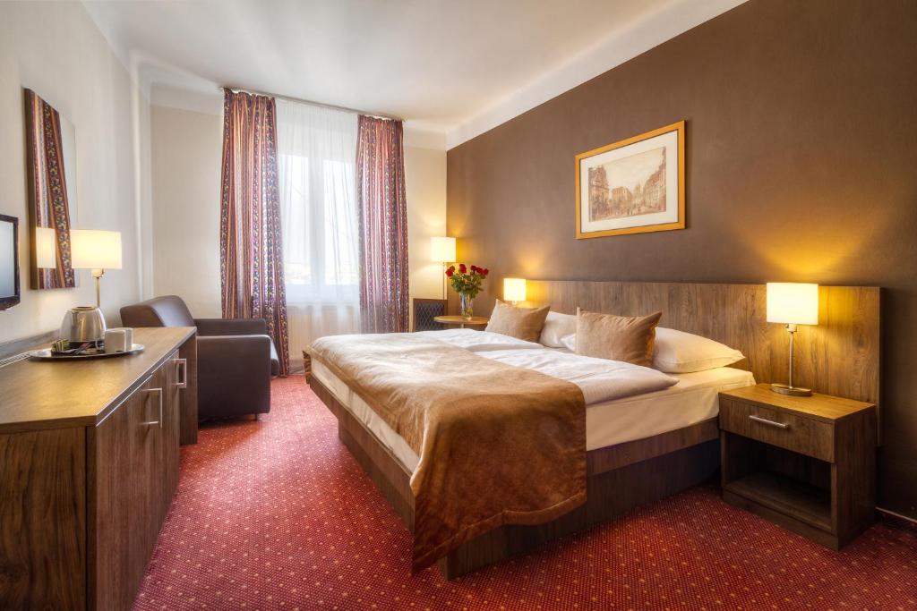 a hotel room with a large bed and a large mirror at Hotel Harmony in Prague