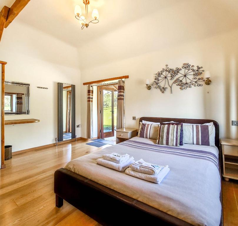 een slaapkamer met een groot bed en 2 handdoeken bij Ta Mill Cottages & Lodges - Olde Granary in Launceston