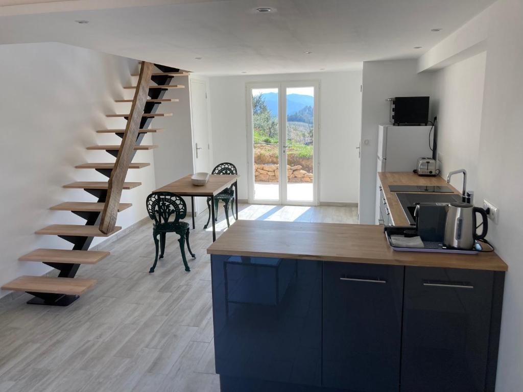 eine Küche mit einer Wendeltreppe und einem Tisch mit einem Esszimmer in der Unterkunft Cottage les Marjoris Tanneron in Tanneron