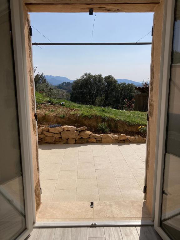 eine offene Tür mit Blick auf eine Terrasse in der Unterkunft Cottage les Marjoris Tanneron in Tanneron