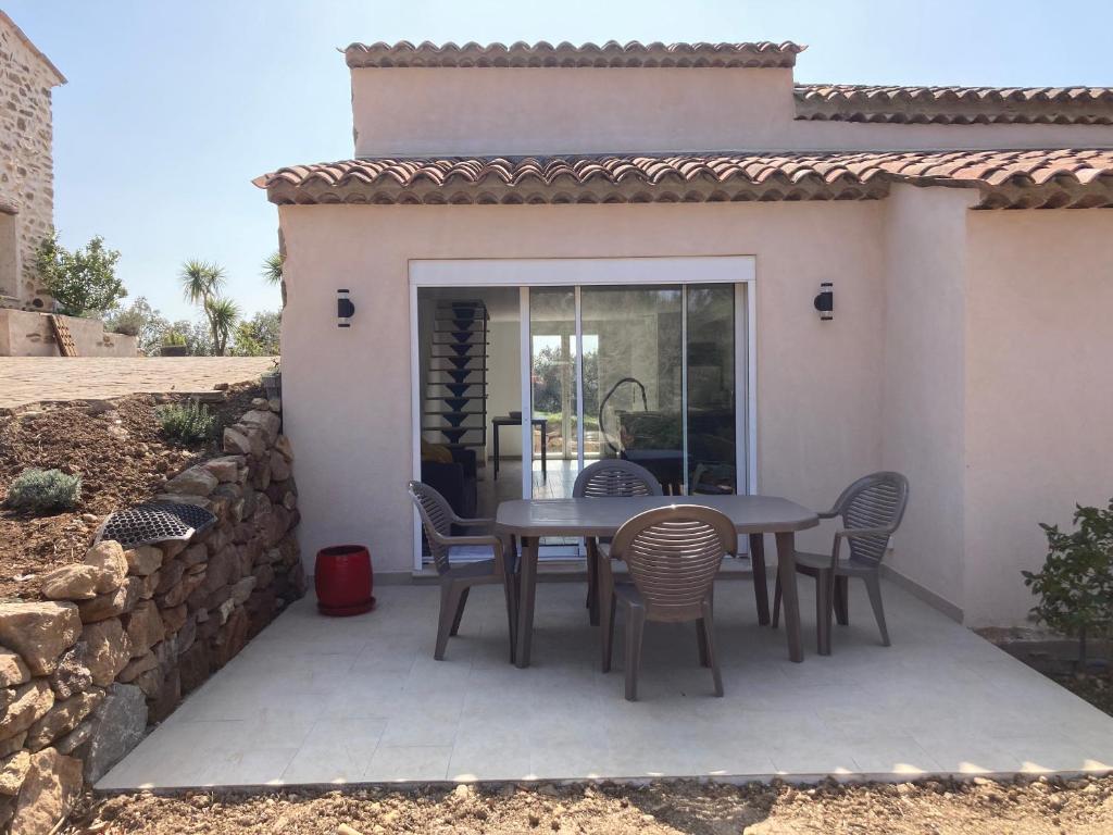 eine Terrasse mit einem Tisch und Stühlen darauf in der Unterkunft Cottage les Marjoris Tanneron in Tanneron