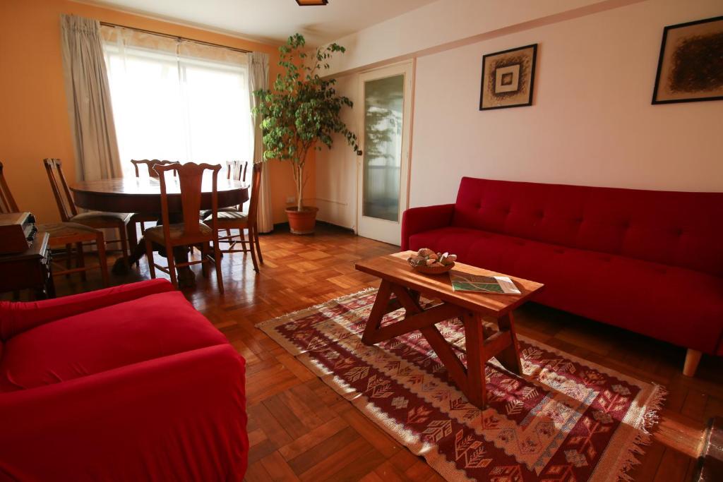 un soggiorno con divano rosso e tavolo di Departamento en Viña del mar a Viña del Mar