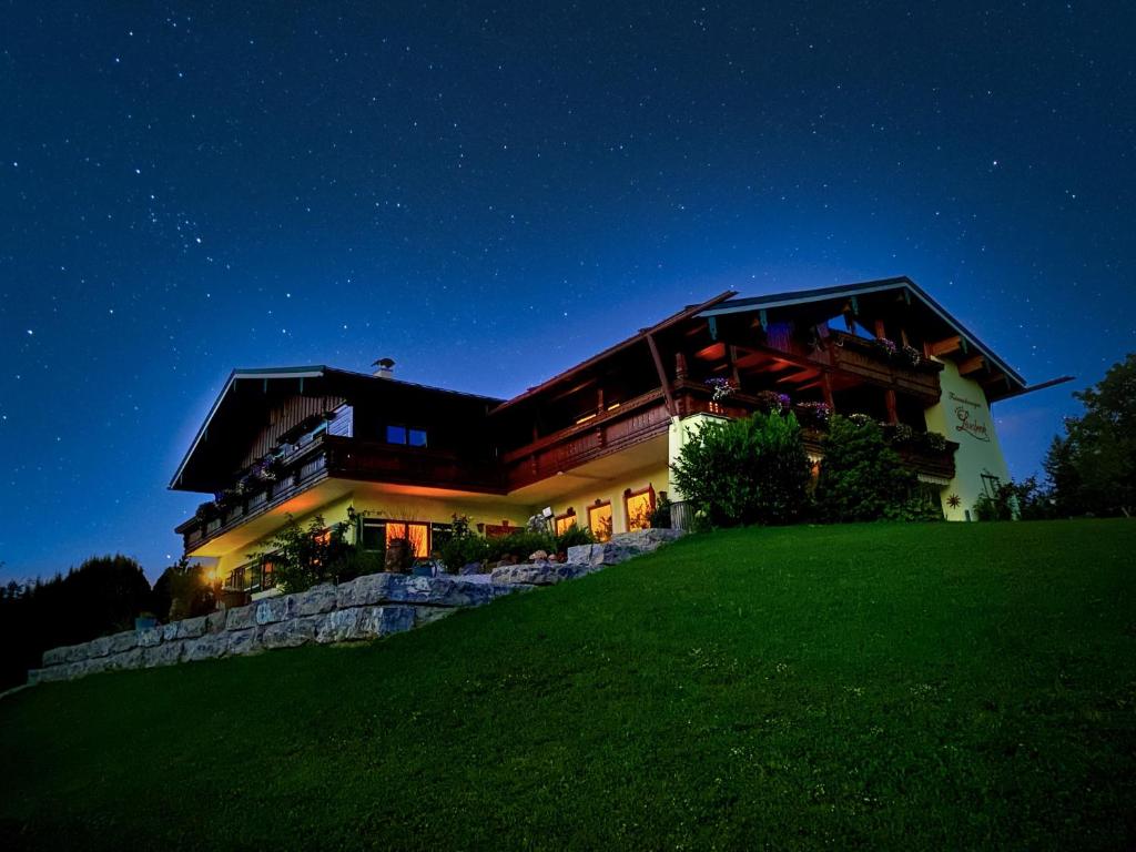 een groot huis op een heuvel 's nachts bij Ferienwohnungen Gästehaus Lärcheck in Berchtesgaden