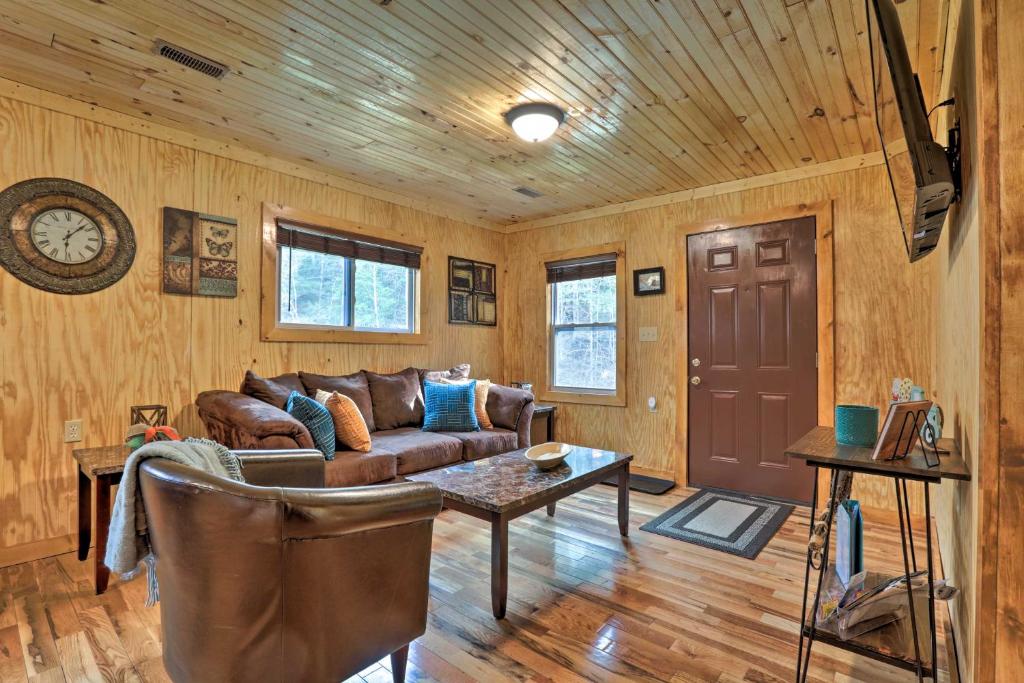 a living room with a couch and a table at Cozy Creekside Cabin about 24 Mi to Red River! in Beattyville