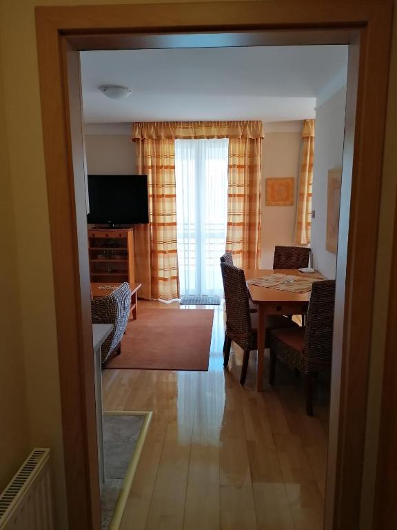 a dining room with a table and chairs and a television at Daniella Apartman in Bükfürdő